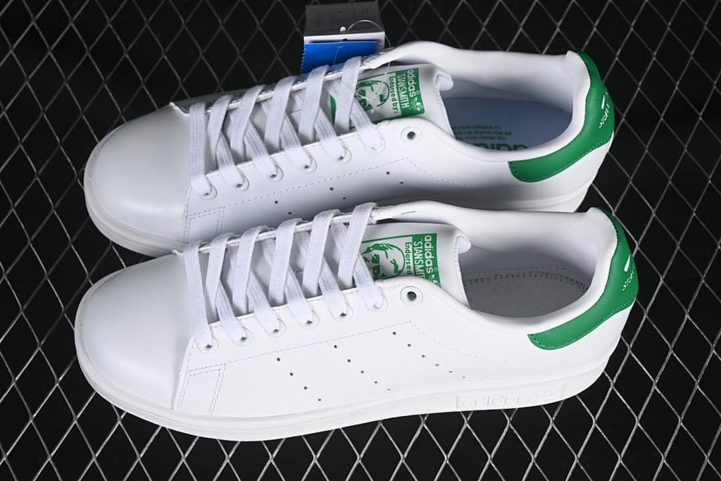 Pair of white Stan Smith sneakers with green heel tabs