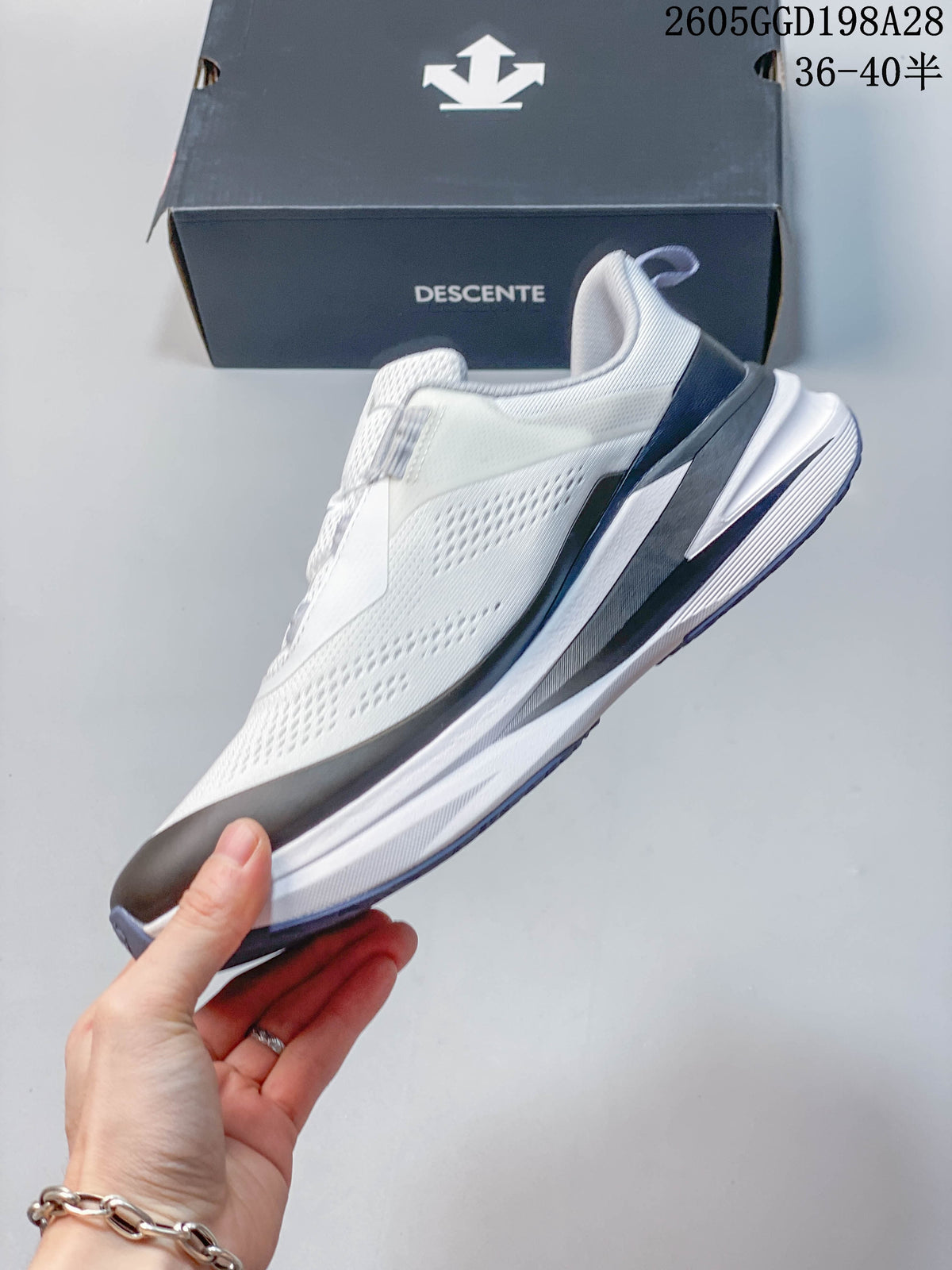 Side profile of the white Descente running shoe showing its BOA closure and thick sculpted sole; image overlay shows code 2605GGD198A28 and size range 36–40.5.