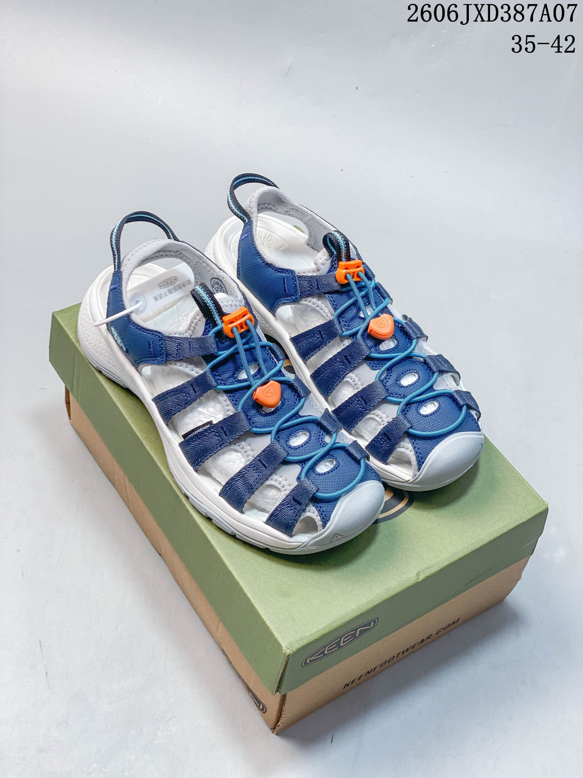 Blue and white KEEN Newport H2 sandals with orange lace details on a shoe box