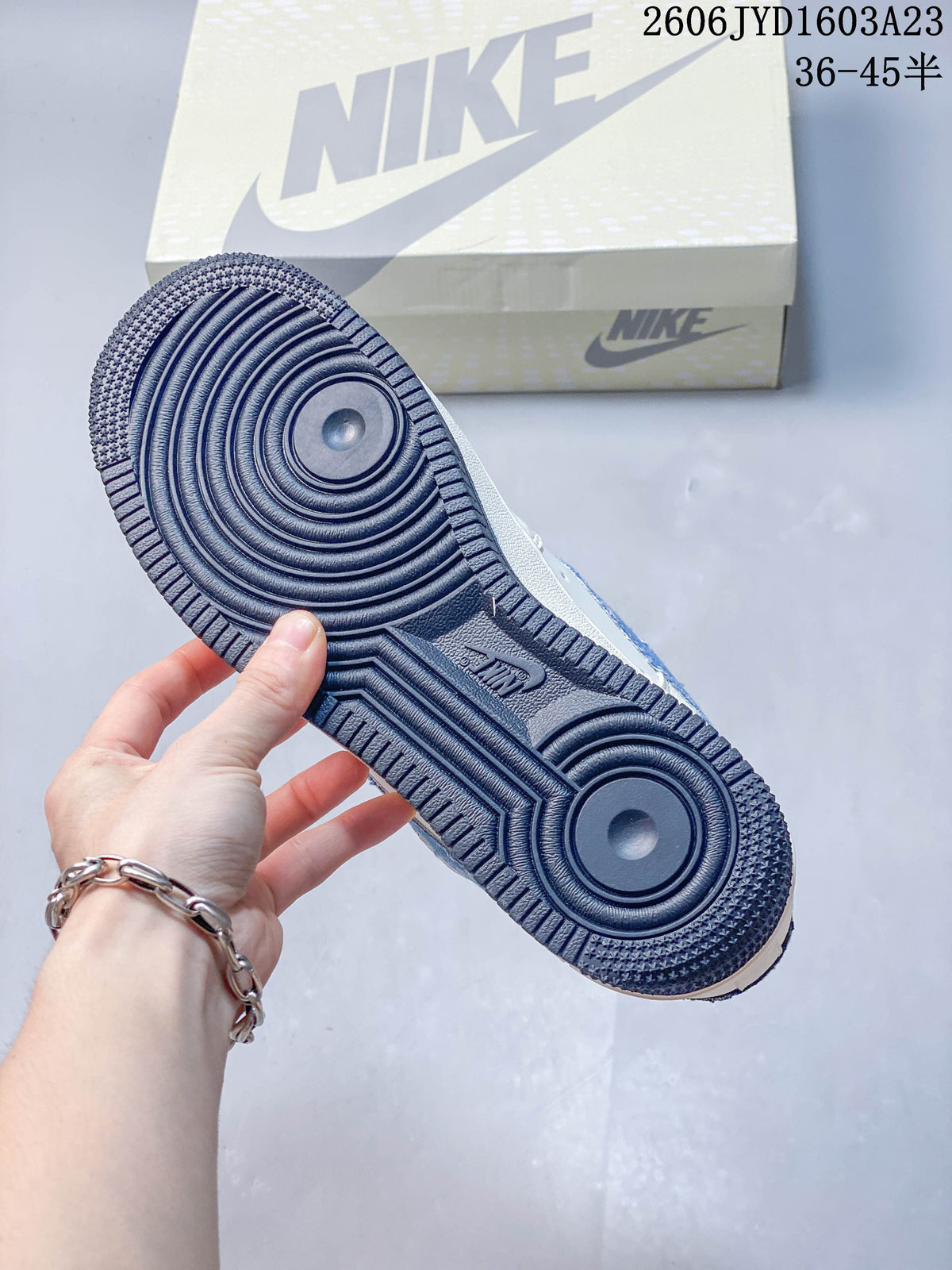 Underside of the sneaker showing a dark navy outsole with circular tread