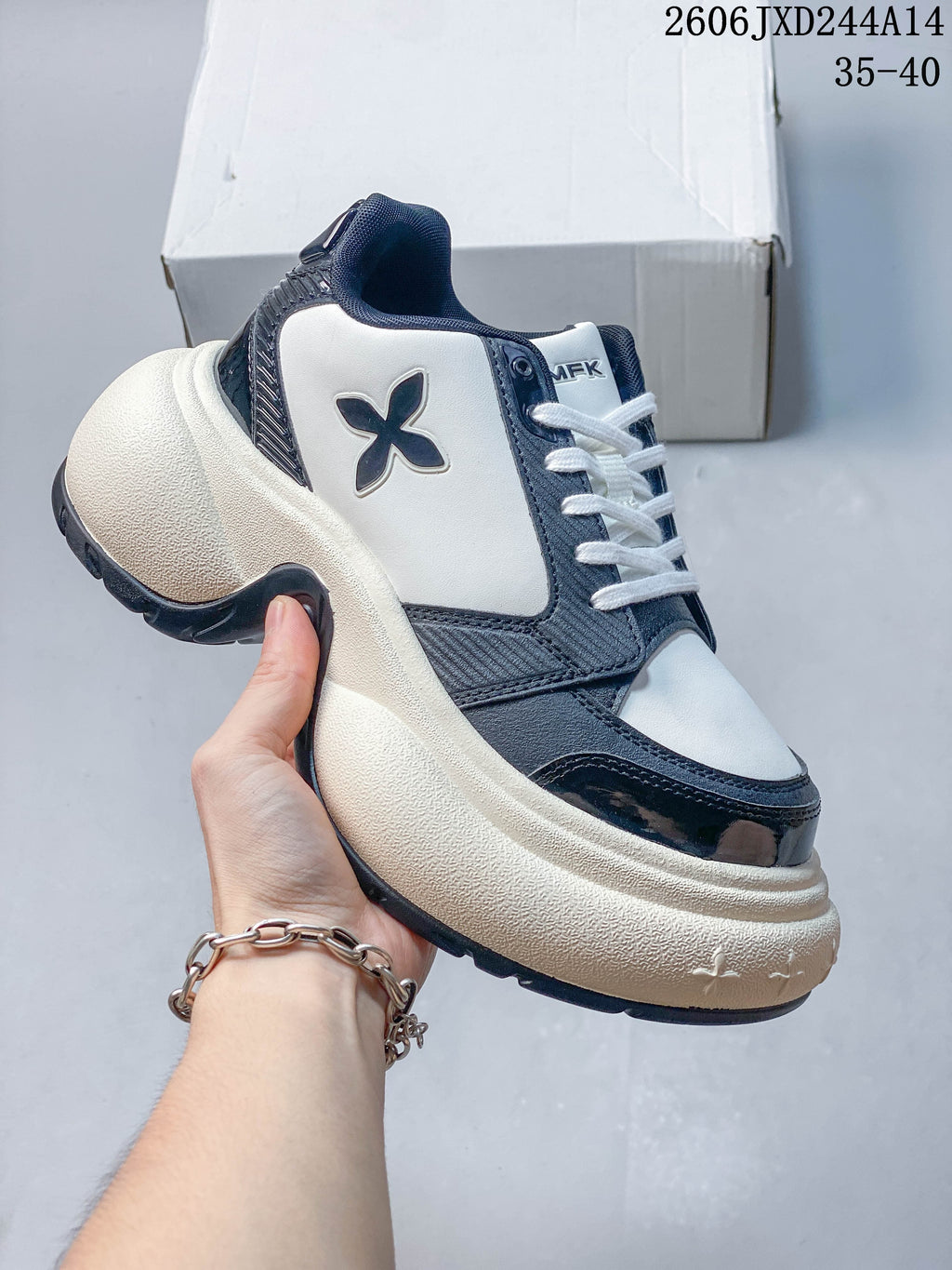Side view of a white and navy SMFK sneaker highlighting its sculpted sole