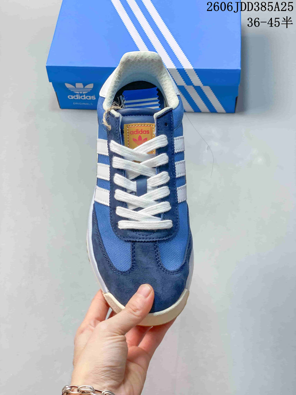 Front view showing the blue and navy upper, white laces, and white stripes.
