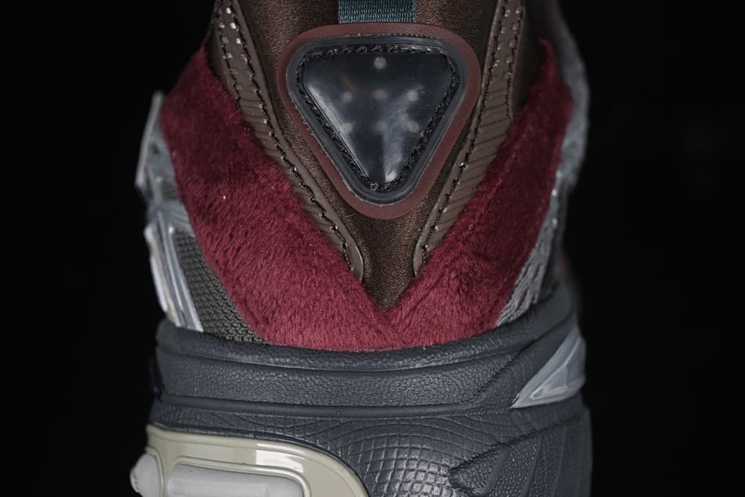 Close-up of the heel with burgundy panels, a triangular detail, and sculpted sole.
