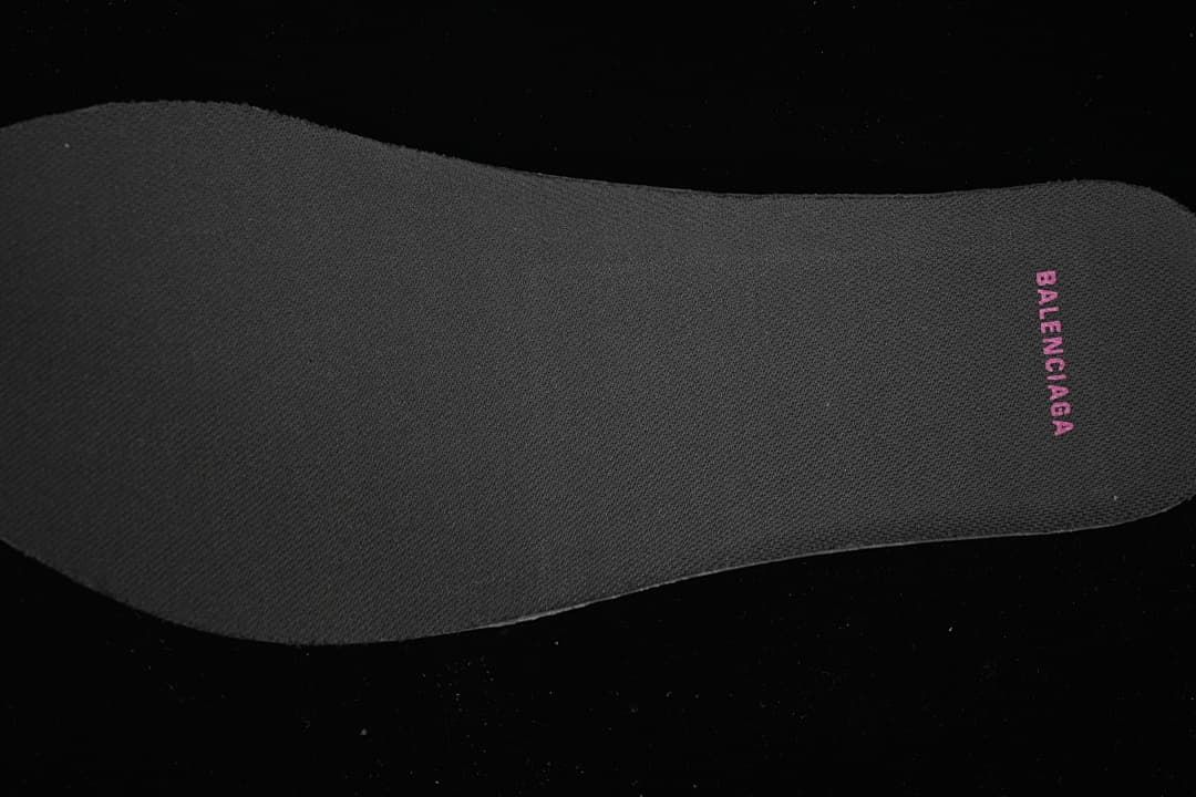 Close-up of a dark insole with pink Balenciaga lettering.