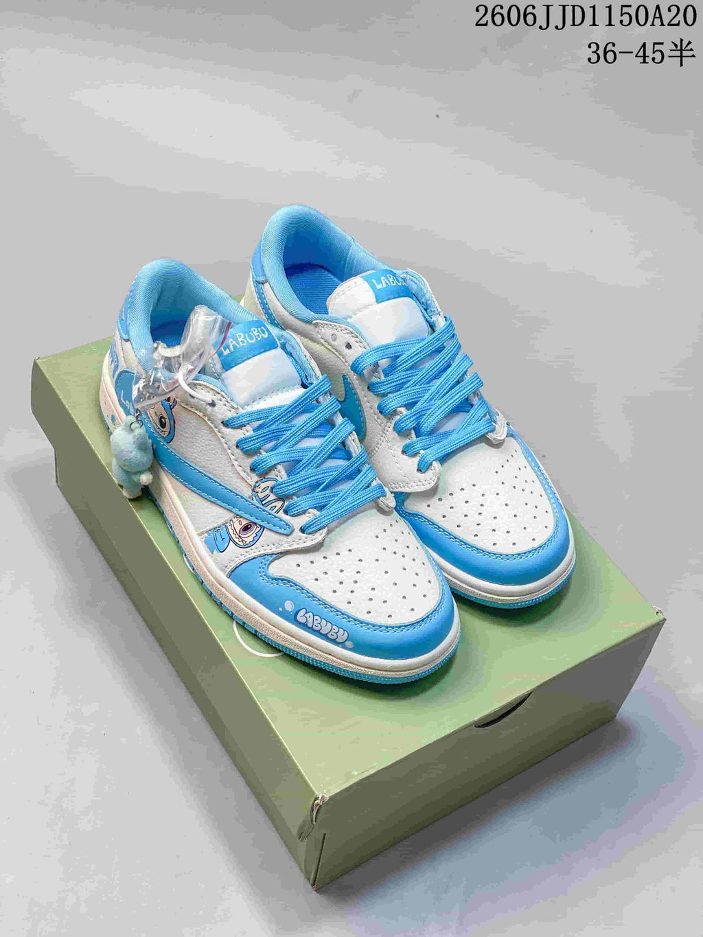 Light blue and white low-top sneakers with character graphics, bright blue laces, and a plush charm.
