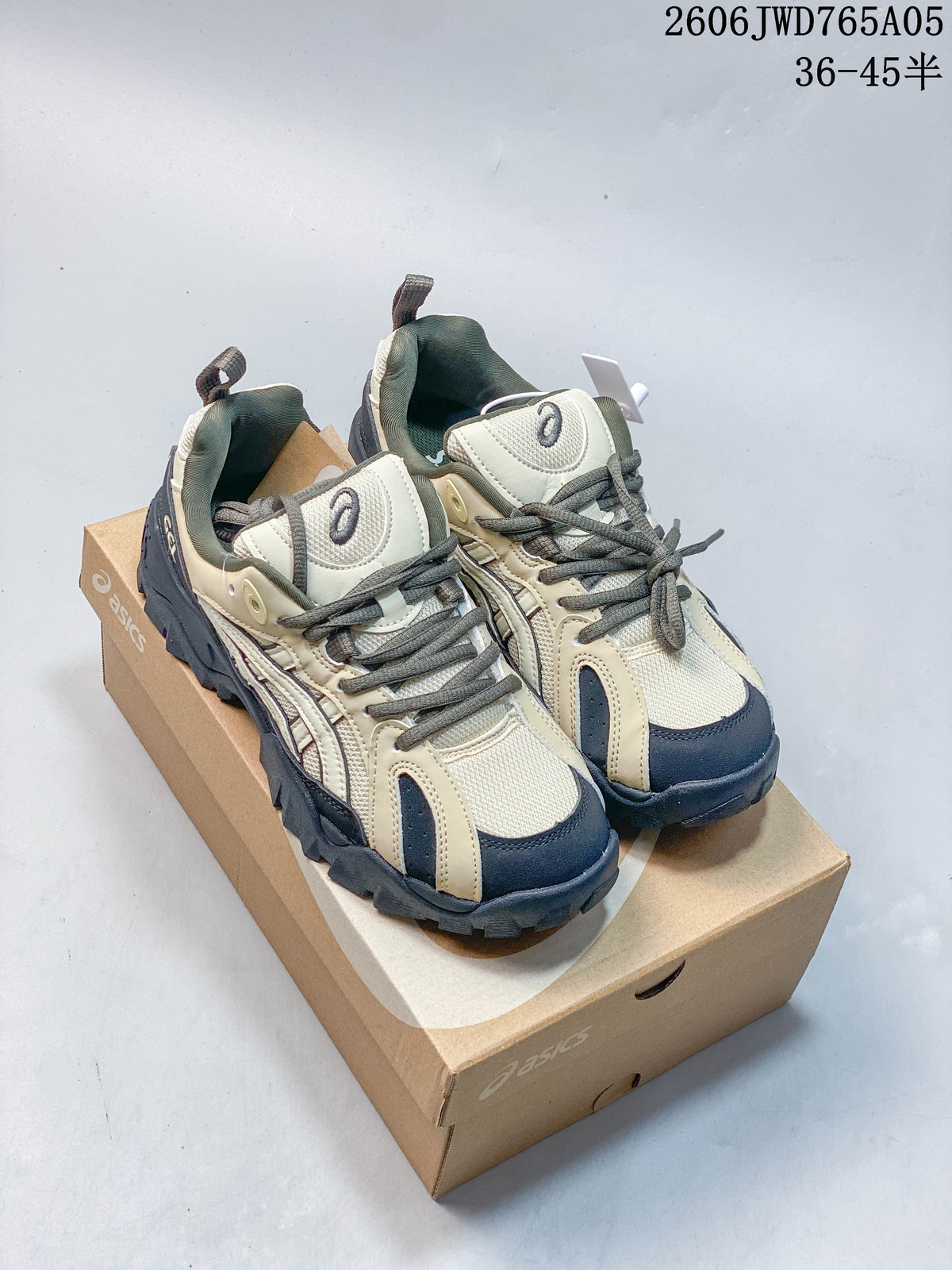 Beige and navy ASICS Gel-TRUCK sneakers shown from the front on a shoe box