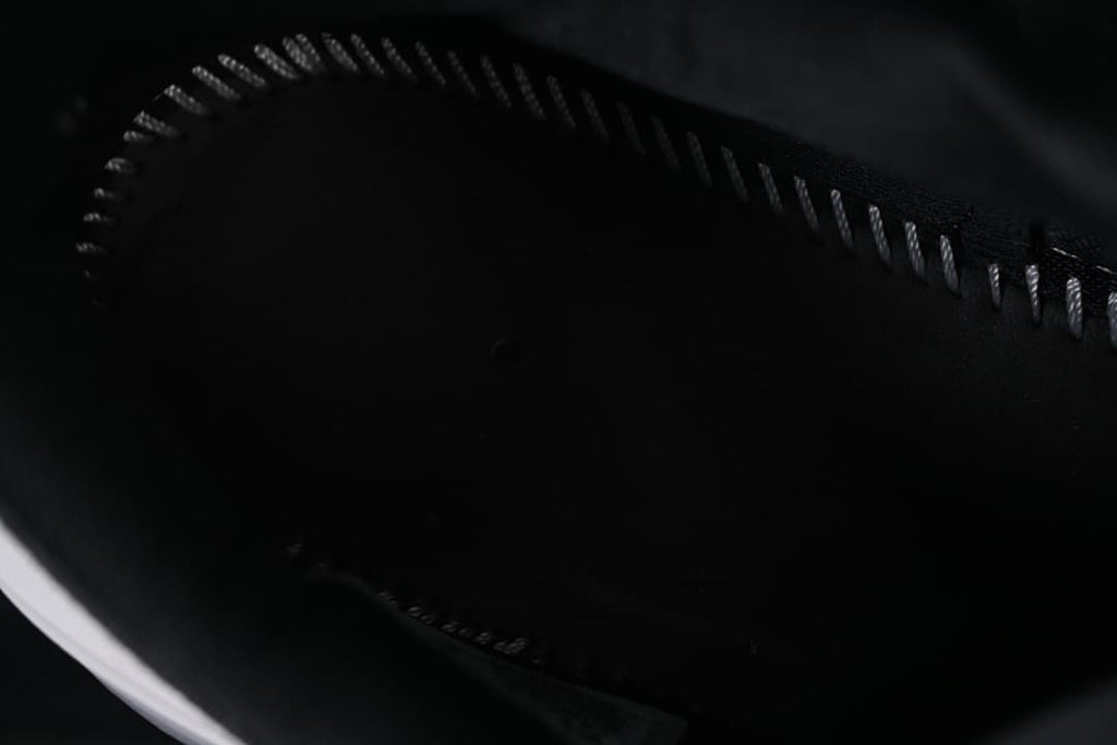 Dark interior of the shoe, viewed close up.