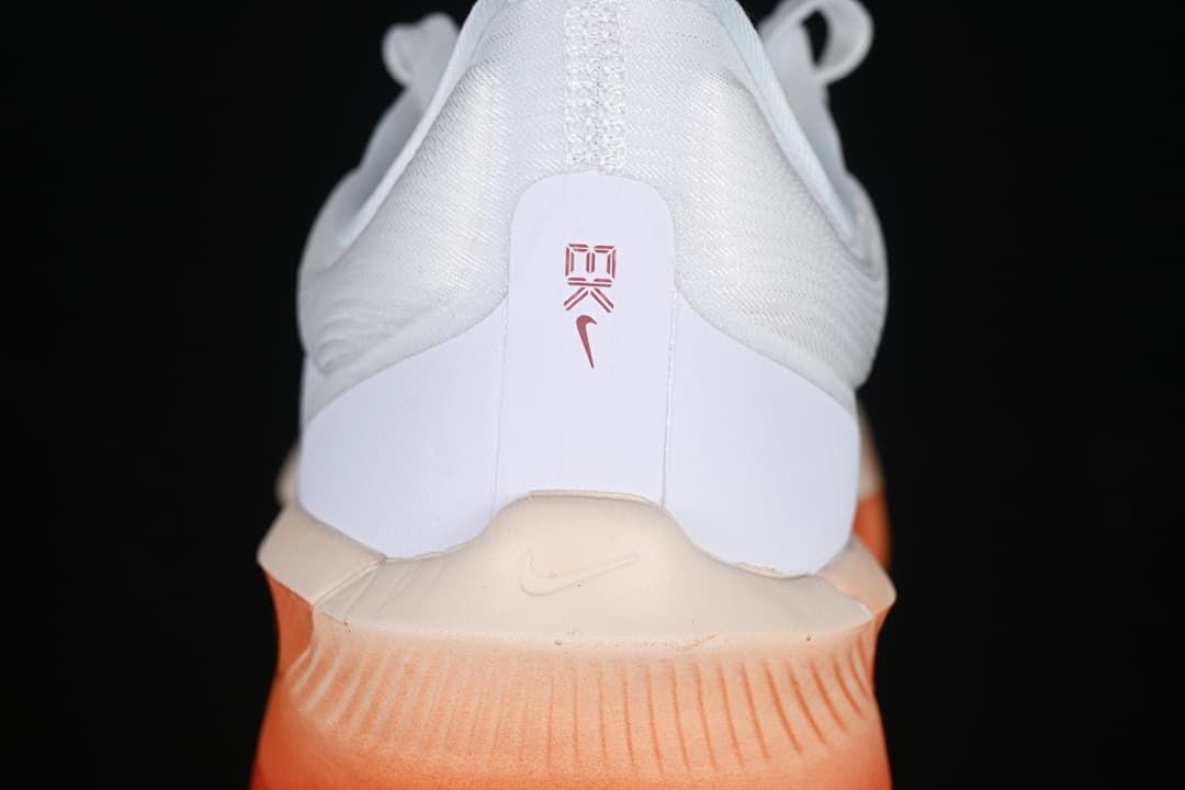 Rear view of the shoe showing heel details and coral-orange sole