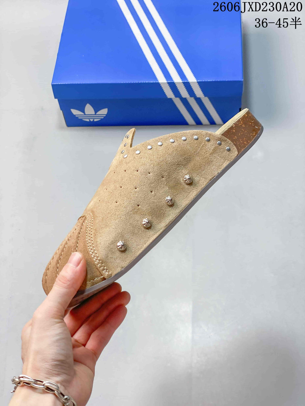 Side profile showing the upper and studs on a tan adidas Adimule mule slide