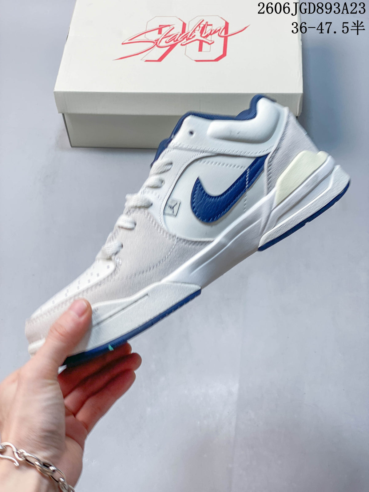Side view of a white Jordan Stadium 90 sneaker with blue accents