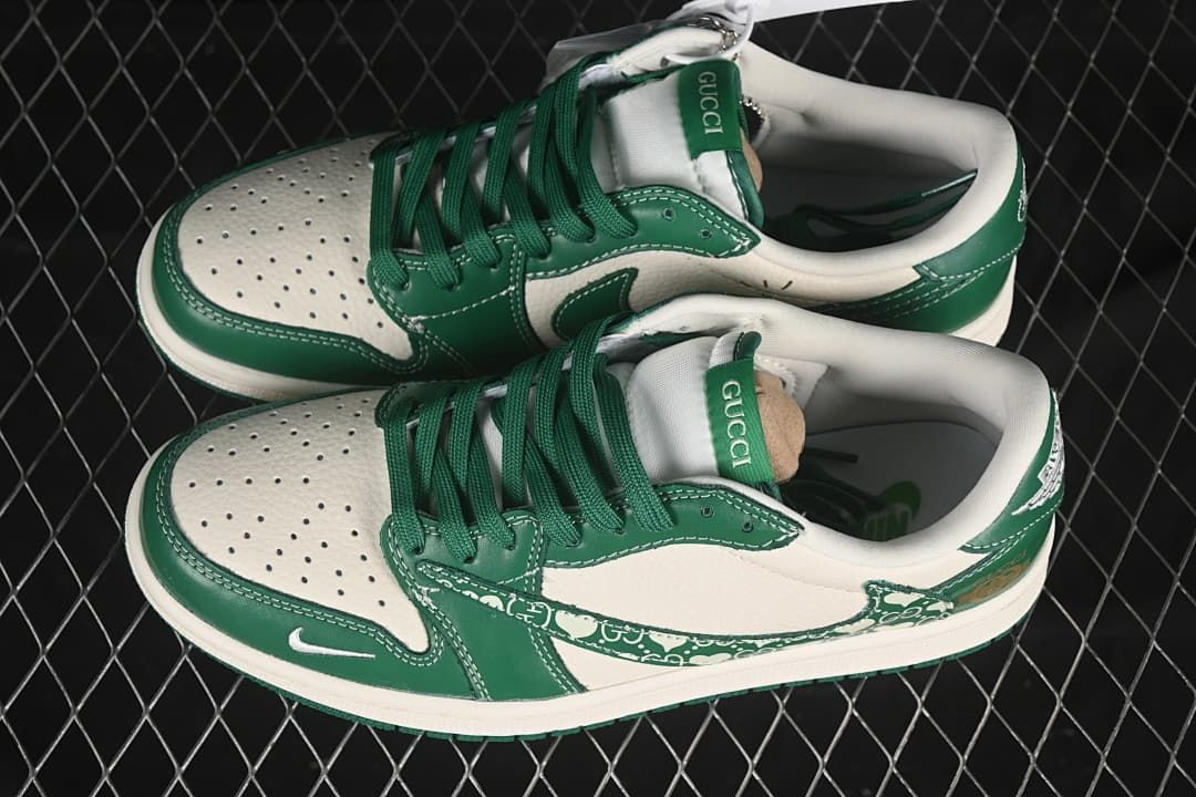Top view of a pair of cream and green low-top sneakers showing green laces and perforated toe panels.
