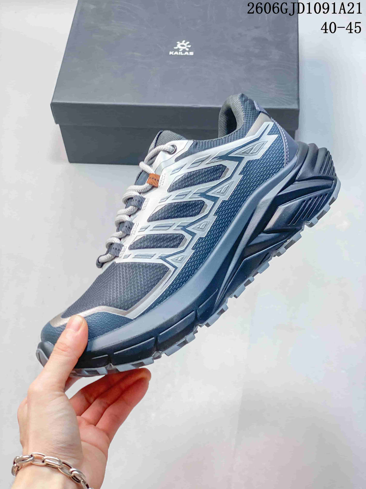 Side view of a blue-gray trail running shoe with light overlays and a lugged sole