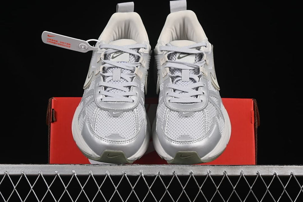 Front view of the pair of Nike V2K Run sneakers on a red shoe box