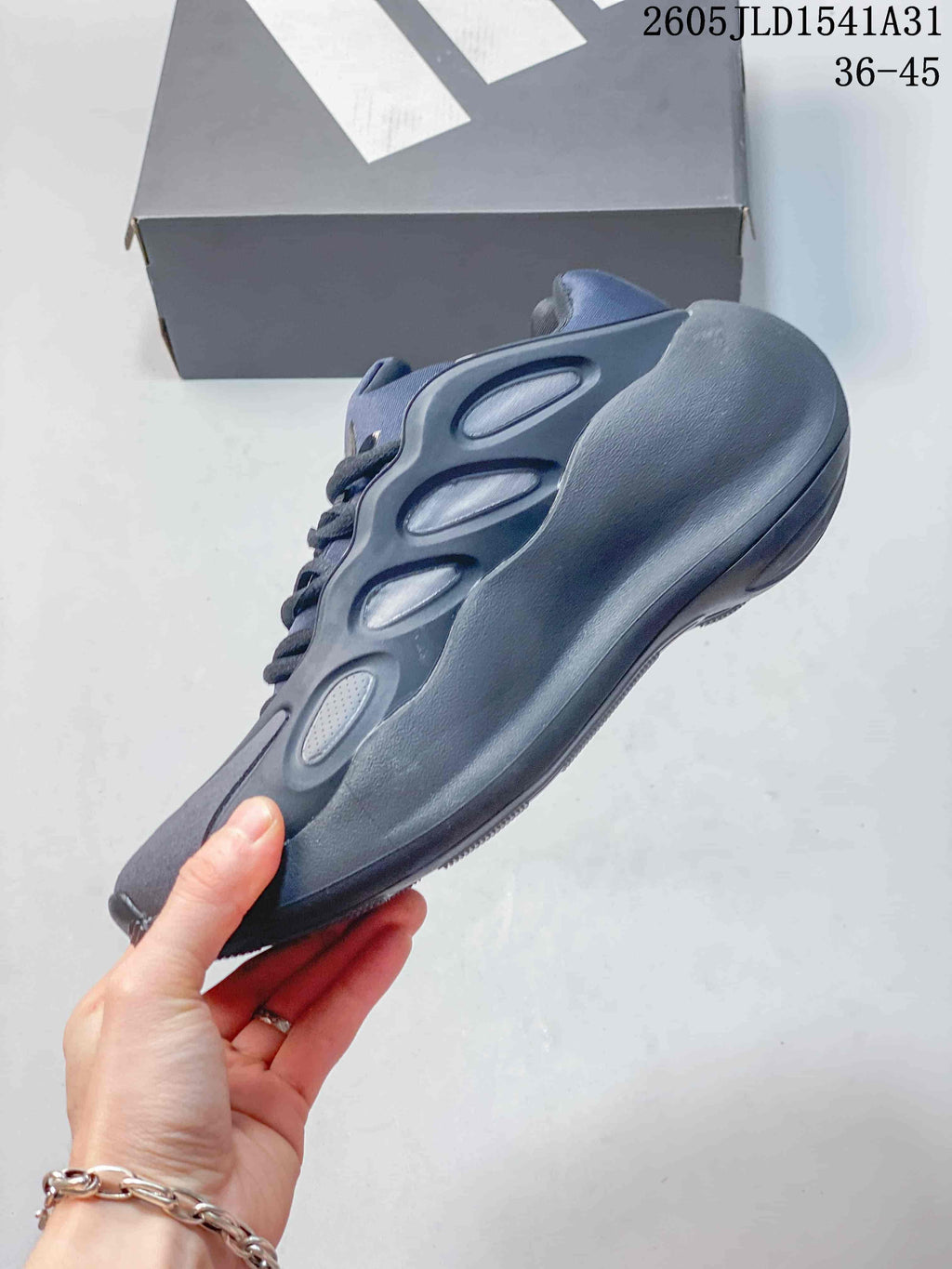 Side profile of the grey and navy Adidas Hyperboost sneaker.