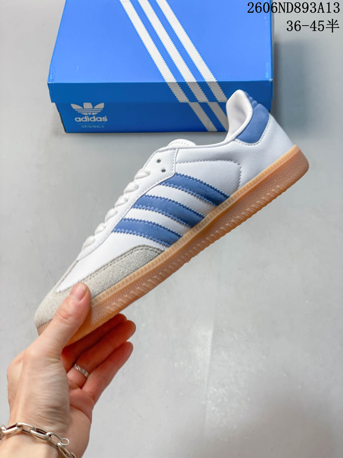 Side view of the sneaker showing blue stripes, a suede-look toe overlay, and gum-colored outsole.
