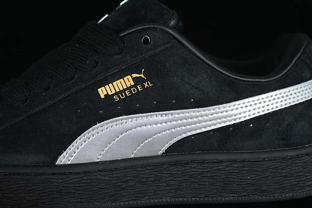 Close-up of the black upper, silver side stripe, and gold Puma Suede XL branding.