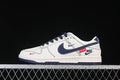 Side view of a white and navy Nike SB Dunk Low-style sneaker with red details