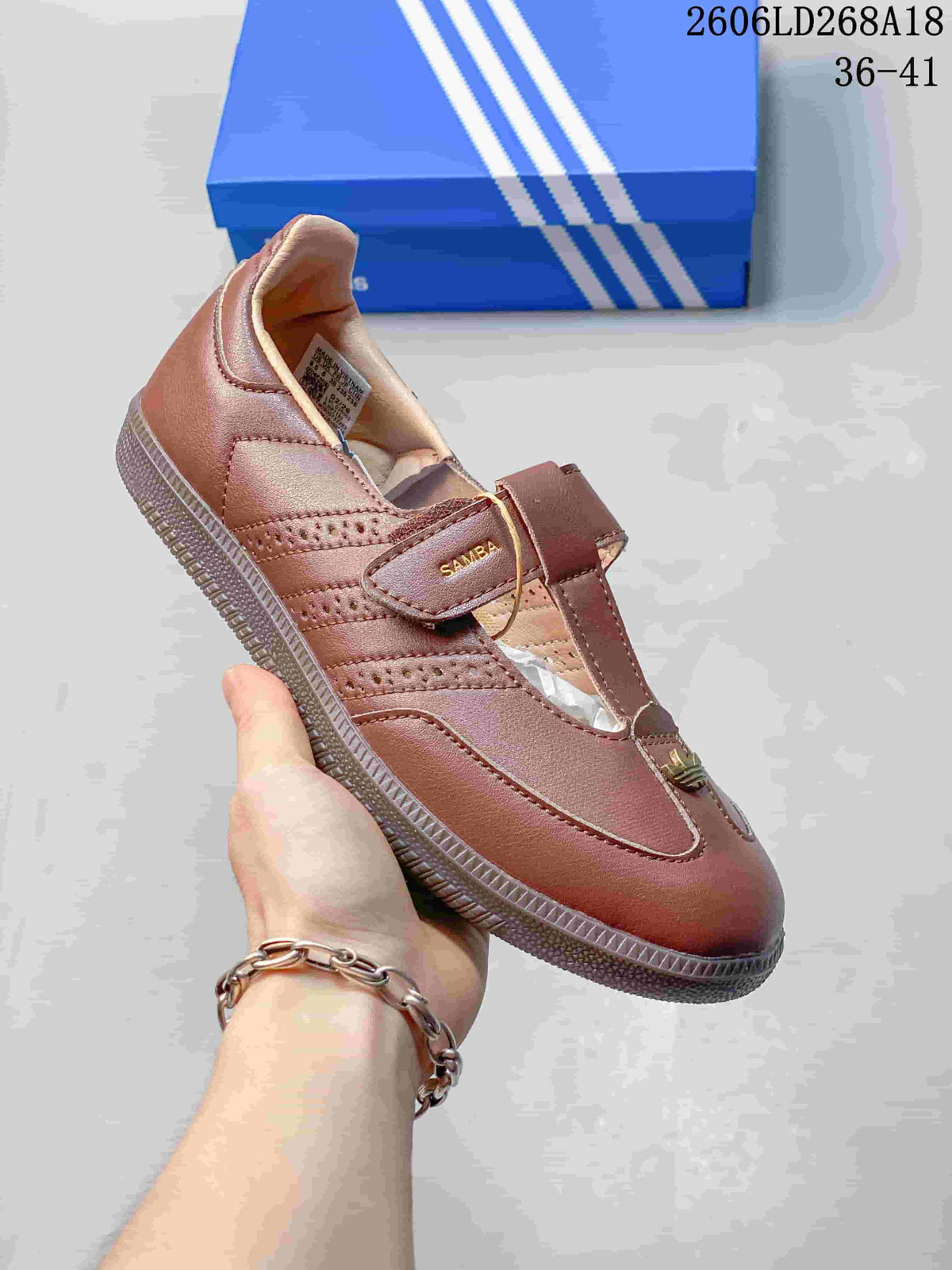Angled view of a brown Samba Jane sneaker showing the strap, perforated side panels and sole