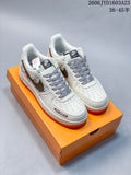 Pair of off-white low-top sneakers with gray accents, patterned laces, and orange outsoles