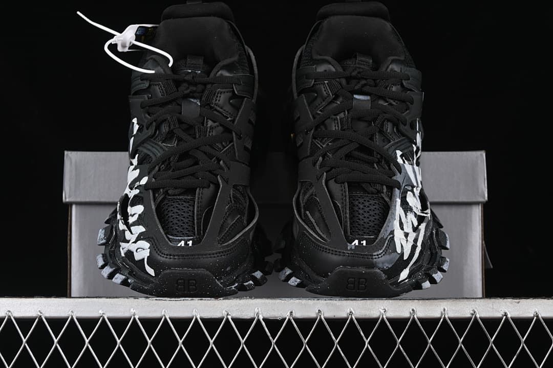 Front view of the pair of black sneakers with white side graphics.
