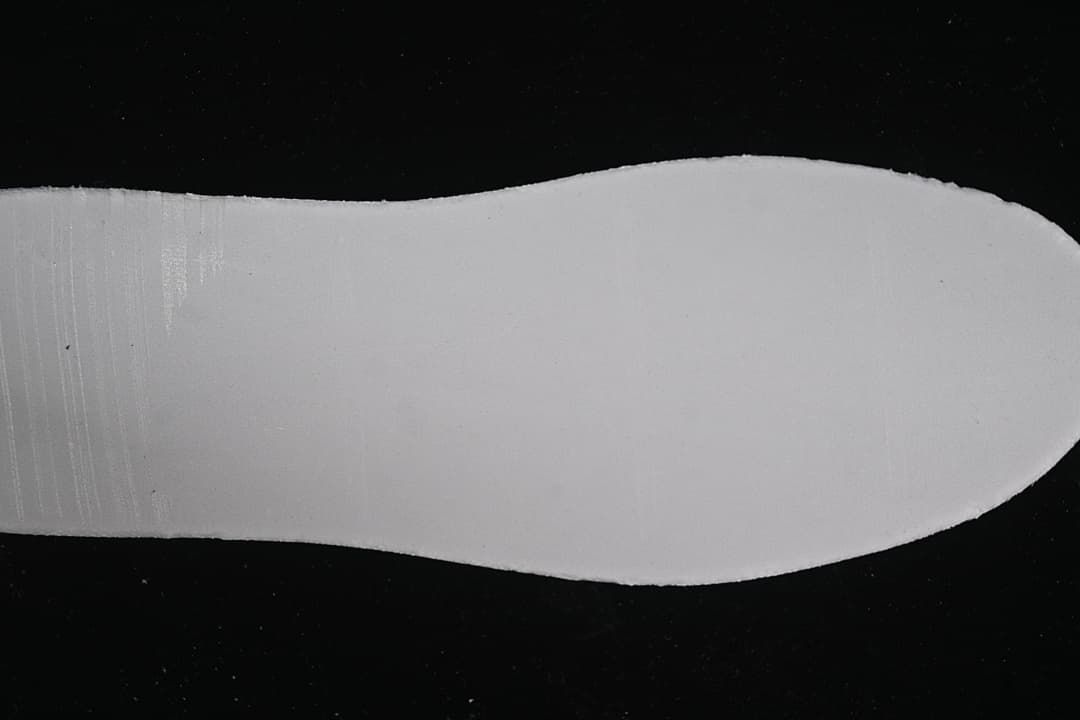 Plain white shoe sole shown against a dark background
