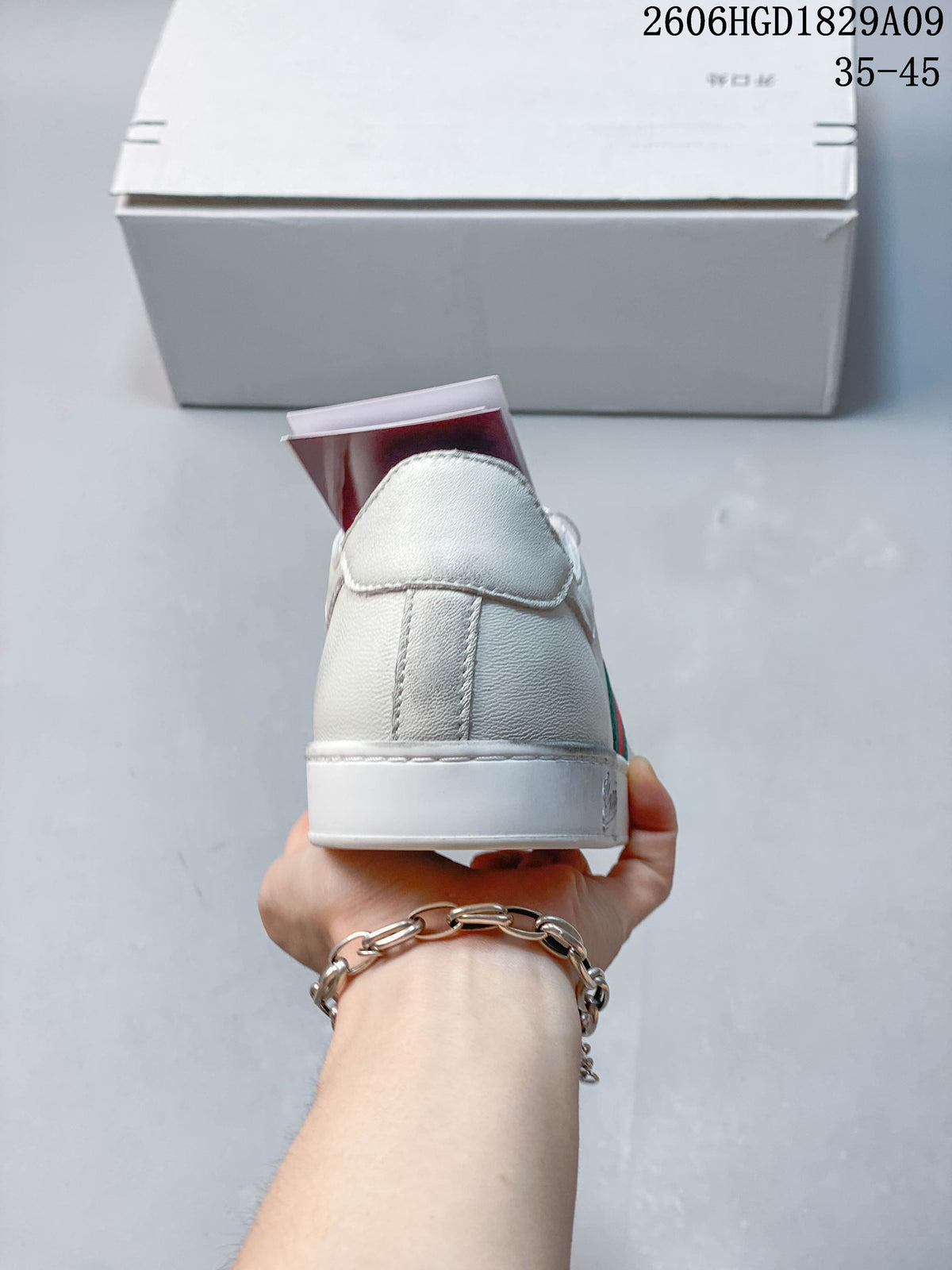 Rear view of a white low-top sneaker with a stitched heel panel.