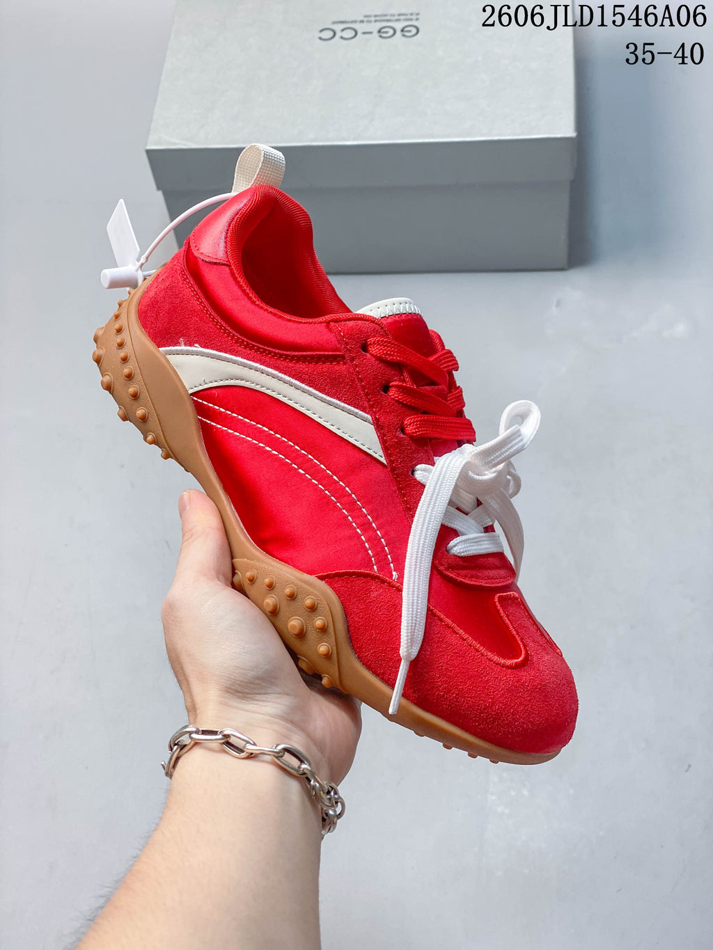 Angled side view of the red and white low-top sneaker with a gum-colored outsole.