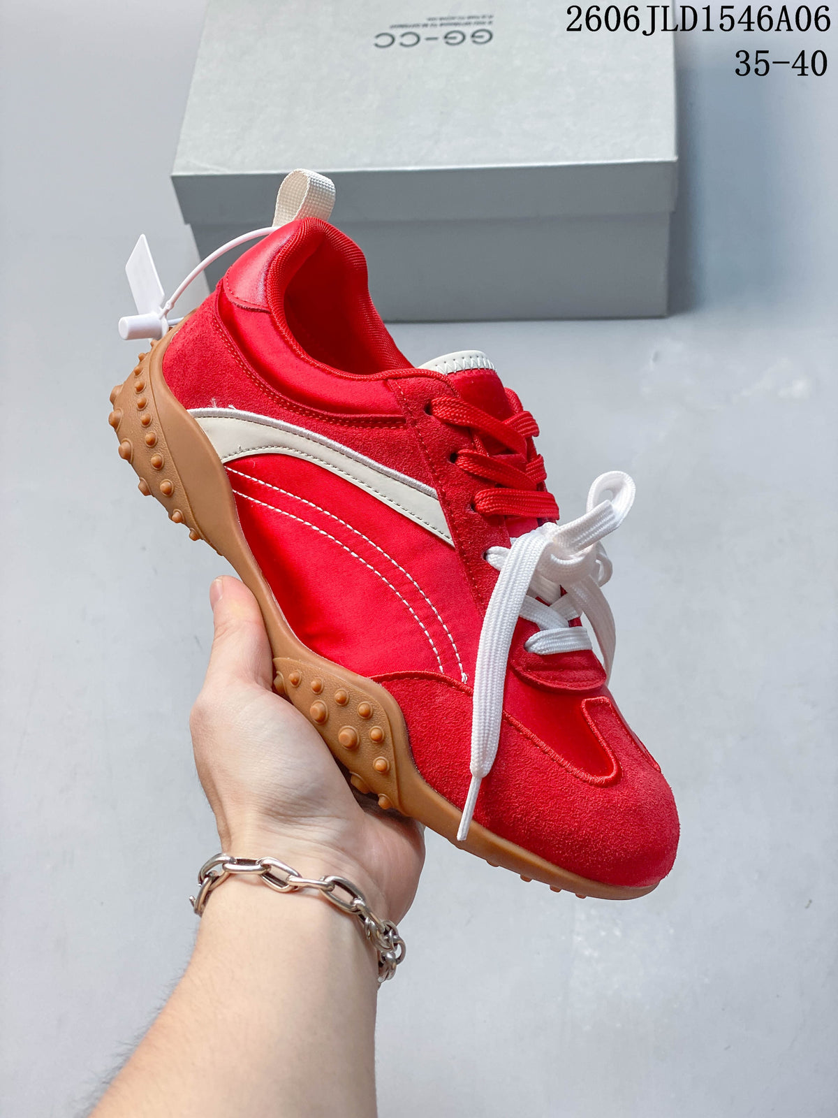 Angled side view of the red and white low-top sneaker with a gum-colored outsole.