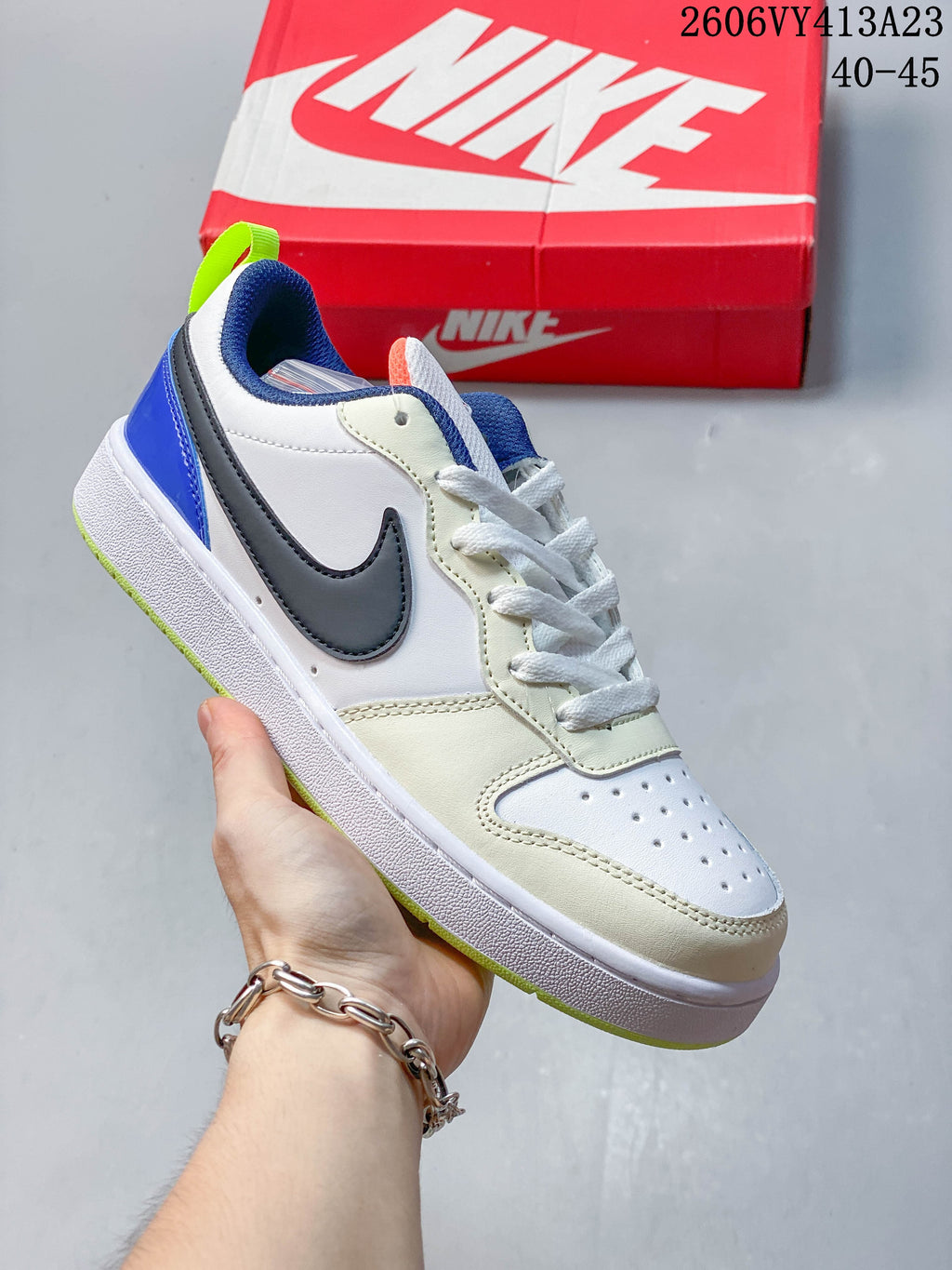 White sneaker with charcoal Swoosh, blue heel, and lime outsole details