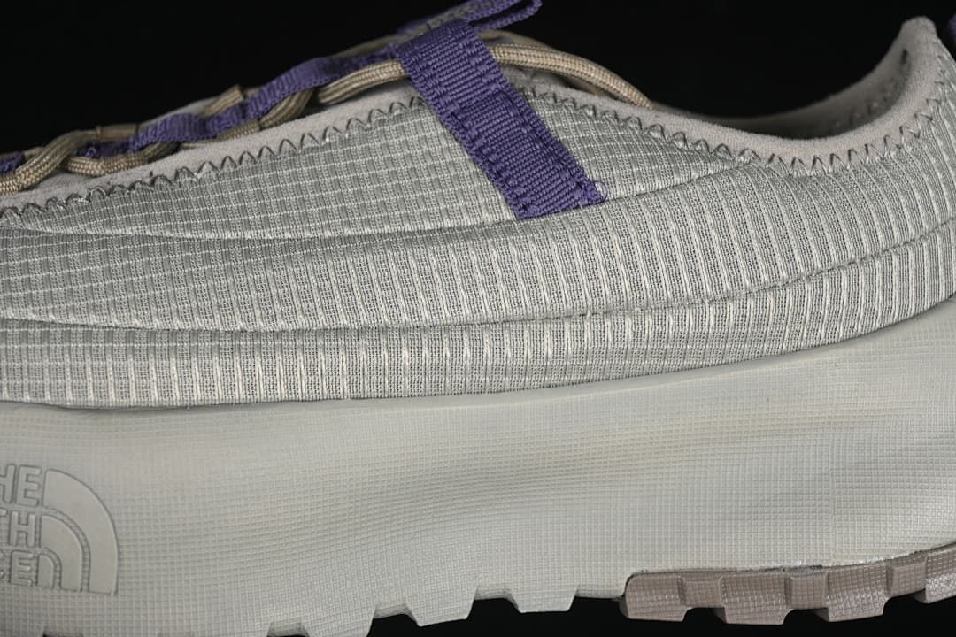 Close-up of the ribbed upper, purple strap and sole.