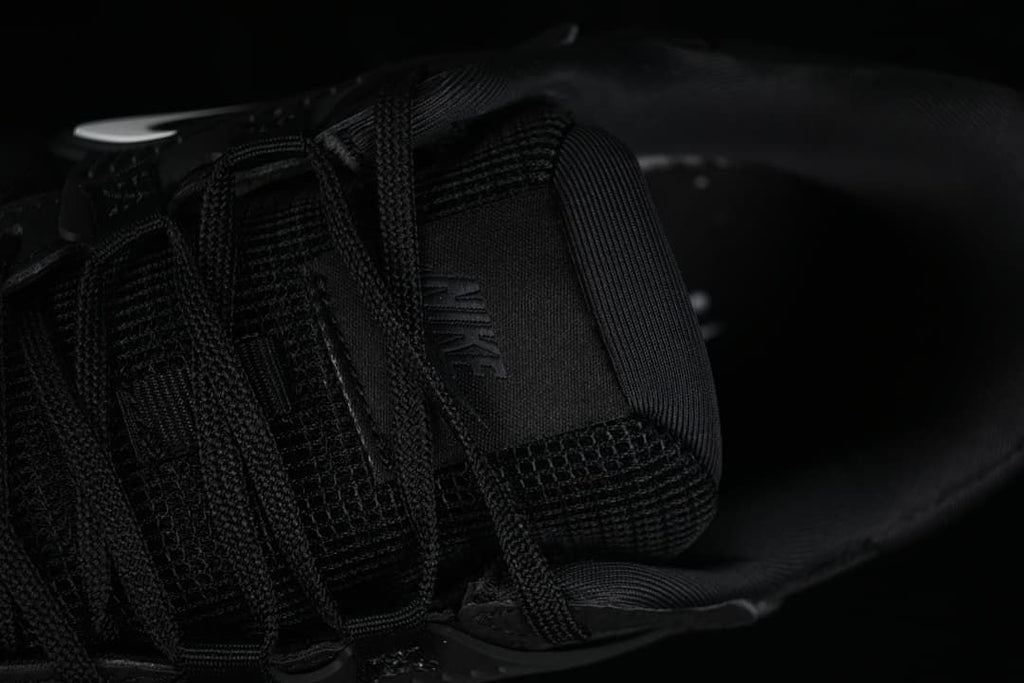 Close-up of the tongue, laces and interior of the black sneaker.