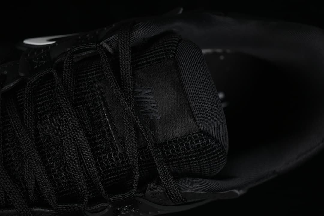 Close-up of the tongue, laces and interior of the black sneaker.