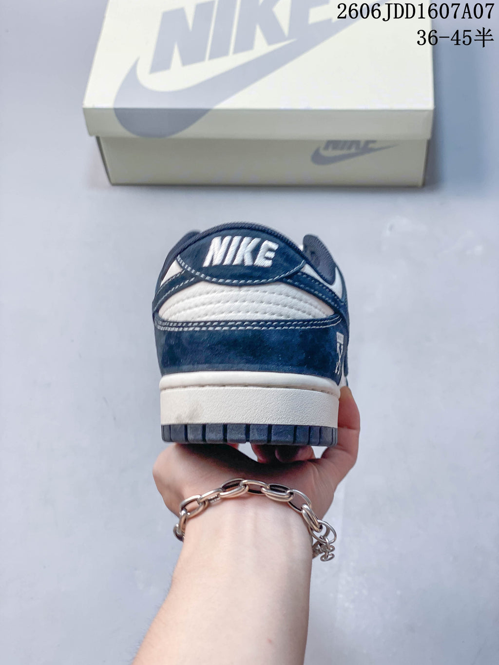 Rear view of a navy and white low-top sneaker with a Nike heel detail