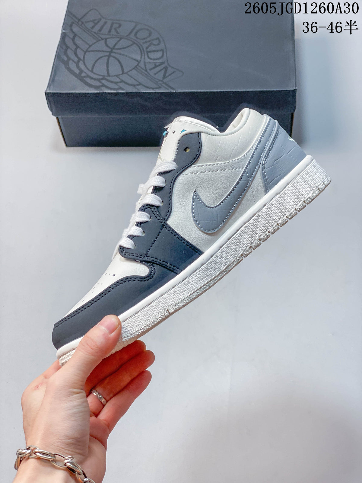 Side view of a white, dark blue, and gray low-top sneaker