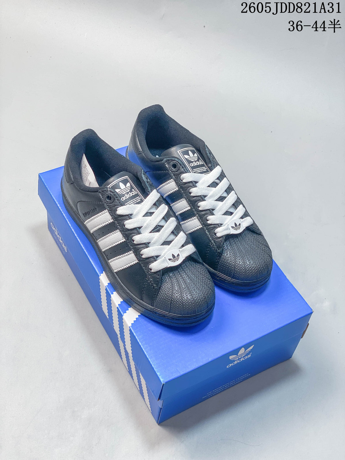 Pair of dark Adidas Superstar sneakers with light stripes, white laces and shell-shaped toes.