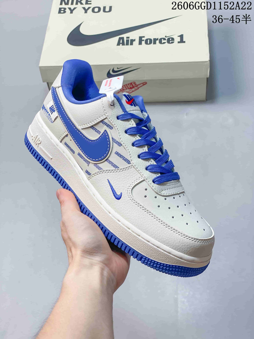 Close-up of a white low-top sneaker with blue laces, blue side accent, and a perforated toe.
