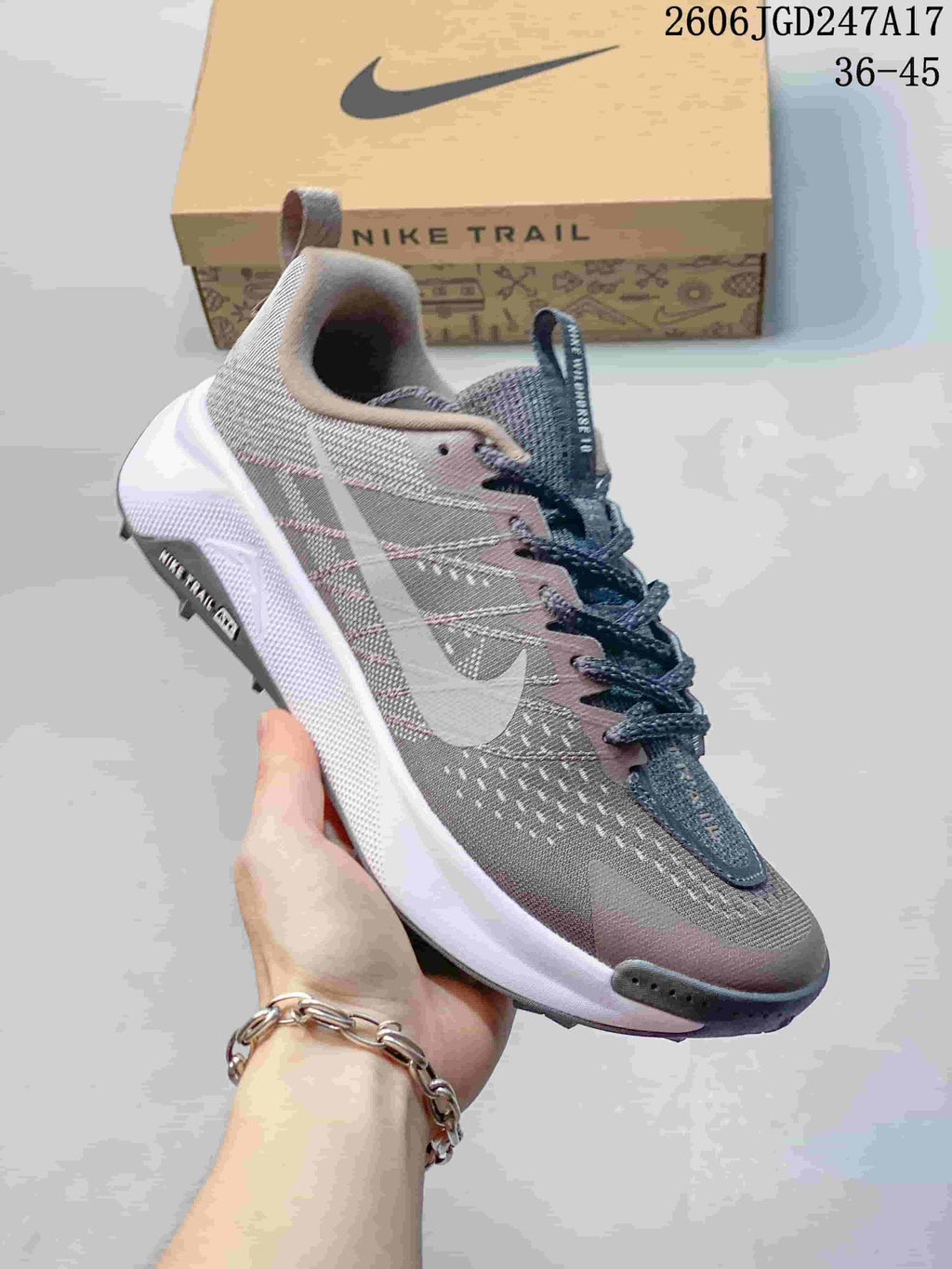 Angled side view of a Nike Wildhorse 10 trail running shoe in gray and muted pink