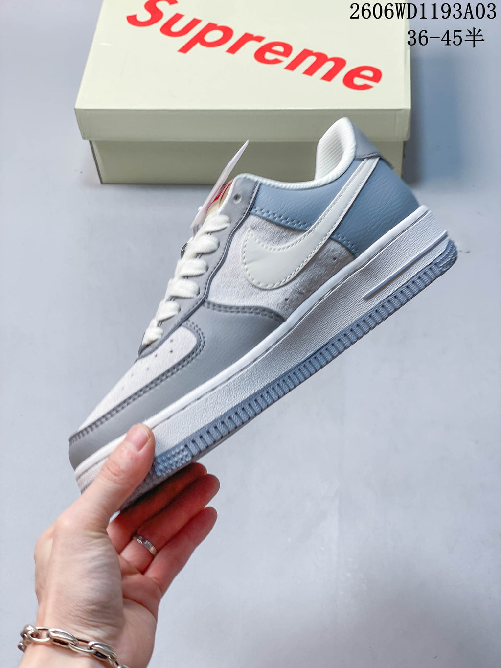 Side view showing the Swoosh, grey panels and white midsole