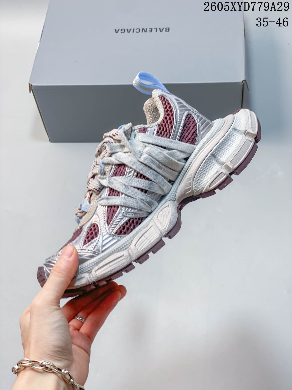 Side view of a Balenciaga Phantom sneaker with silver overlays and burgundy panels.