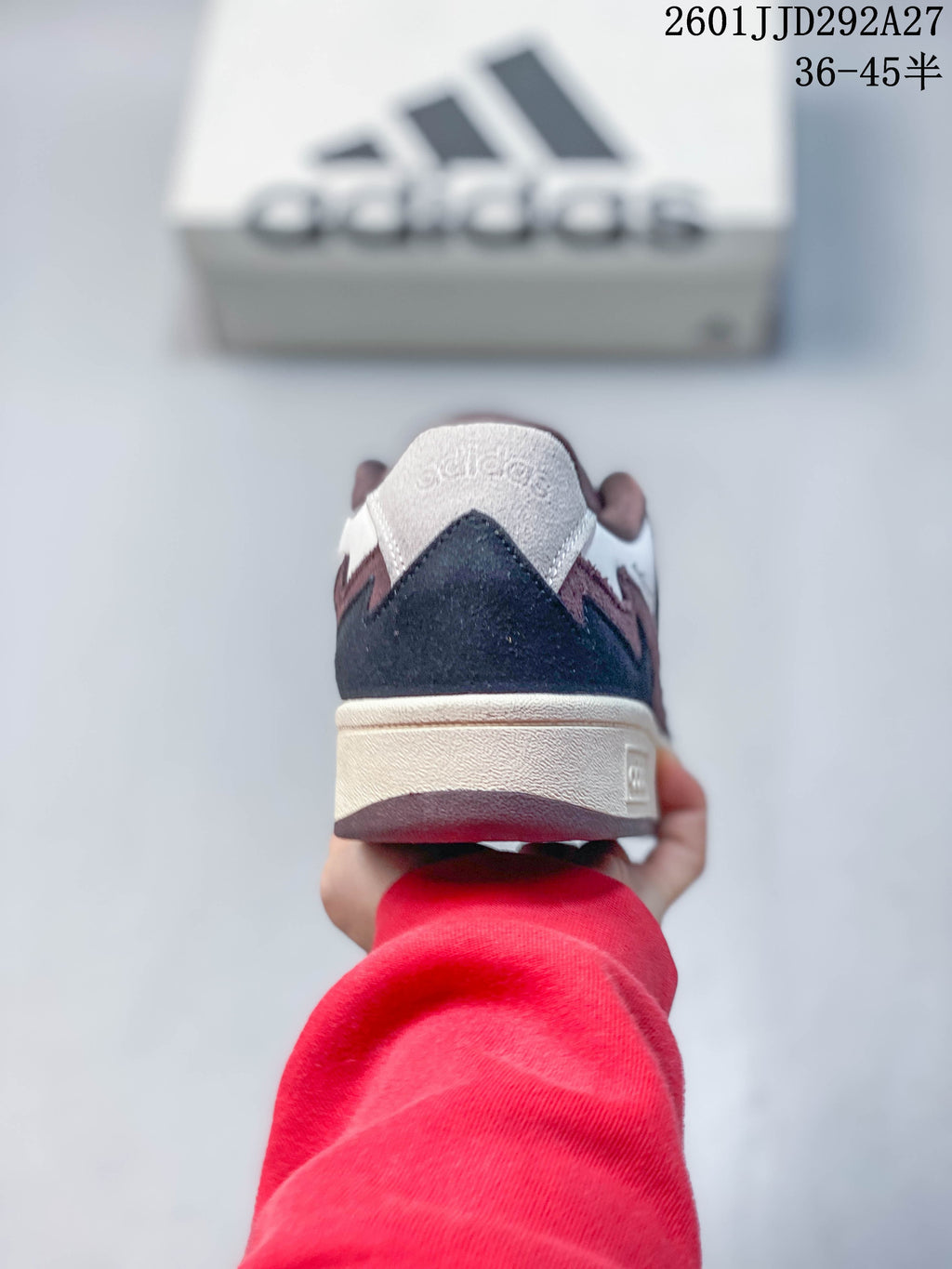 Rear view showing the contrasting heel panels and cream-colored midsole of an Adidas Wcard Adv sneaker.