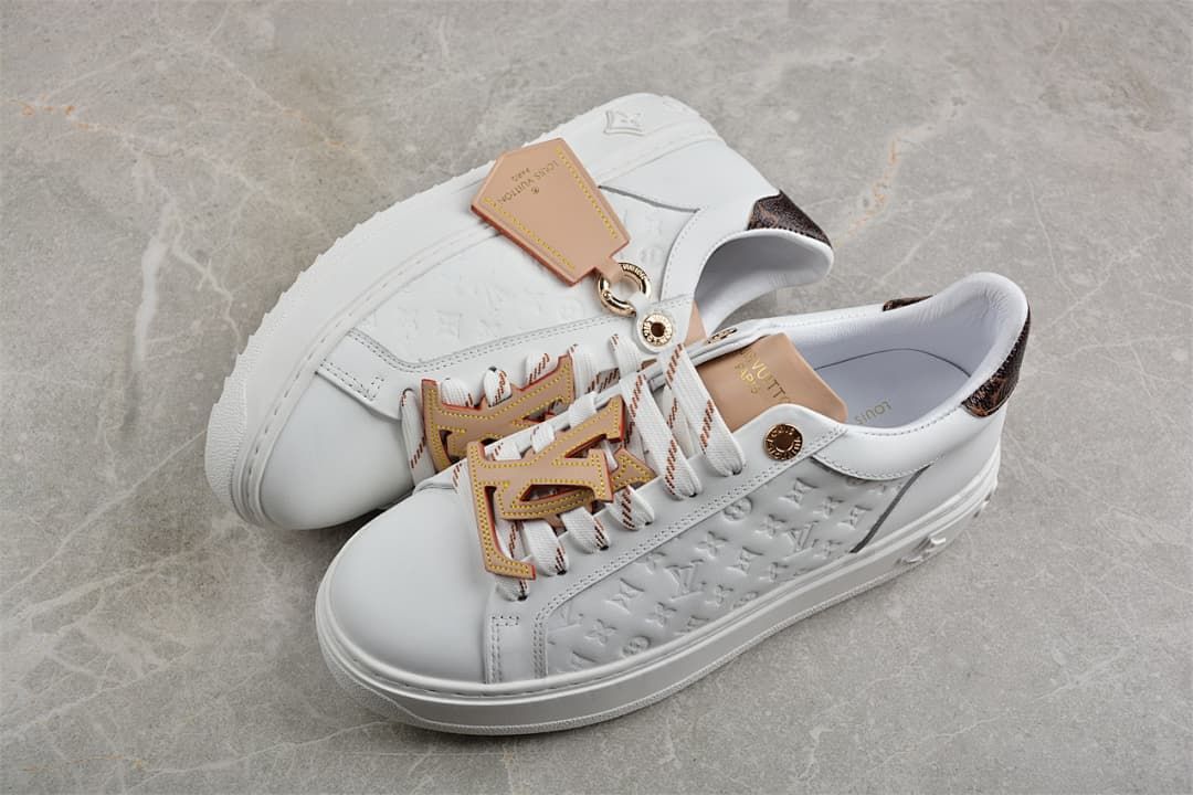 Pair of white platform sneakers with brown heel accents and decorative laces