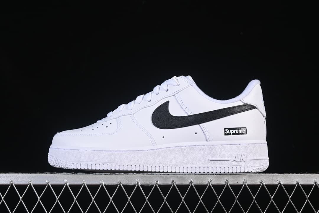 White low-top sneaker with black Swoosh and Supreme box logo, side view