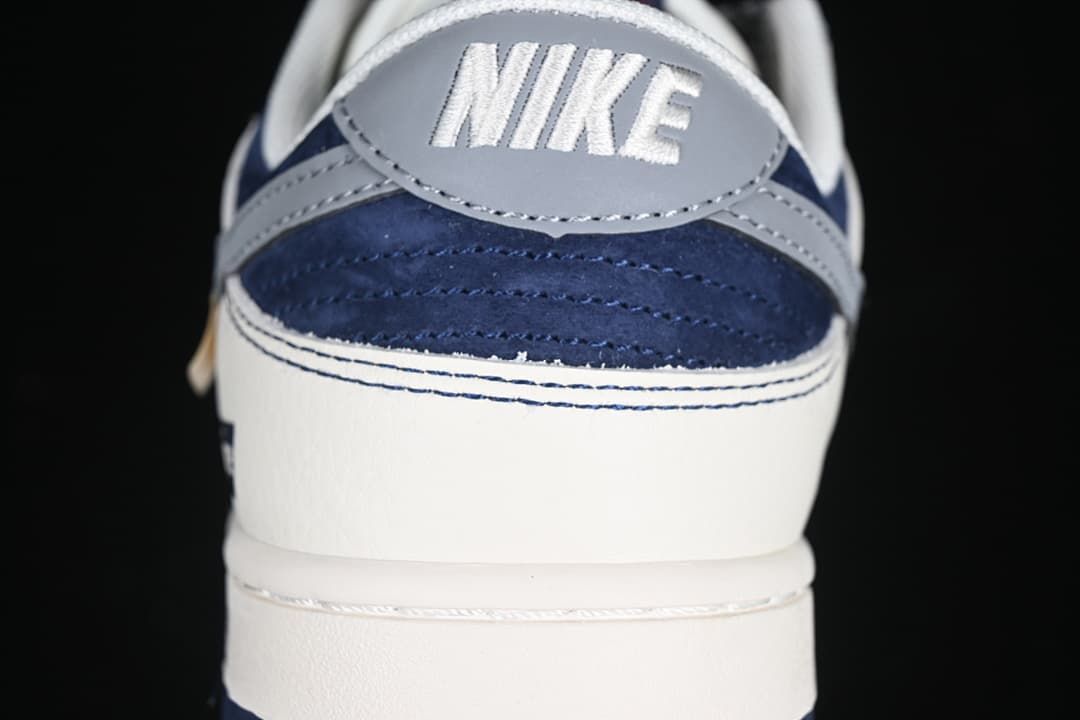 Close-up of the heel with gray Nike branding, navy panels, and off-white sections.