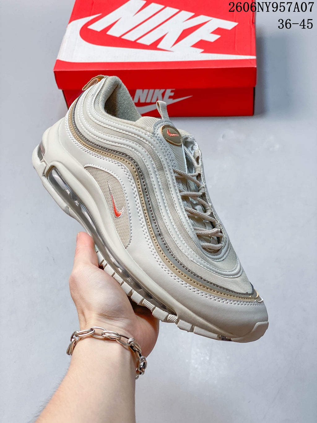 Angled side view of a beige Nike Air Max 97 sneaker with layered wavy panels