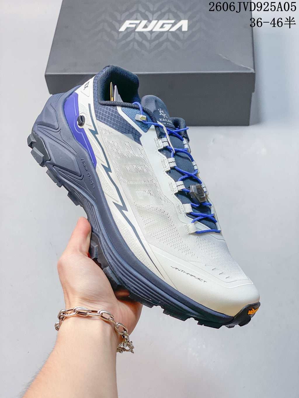 Angled side view of the shoe with its blue-gray sole and lugged tread.