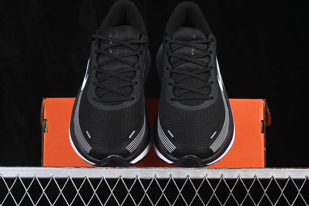 Front view of the pair of black shoes placed on an orange box