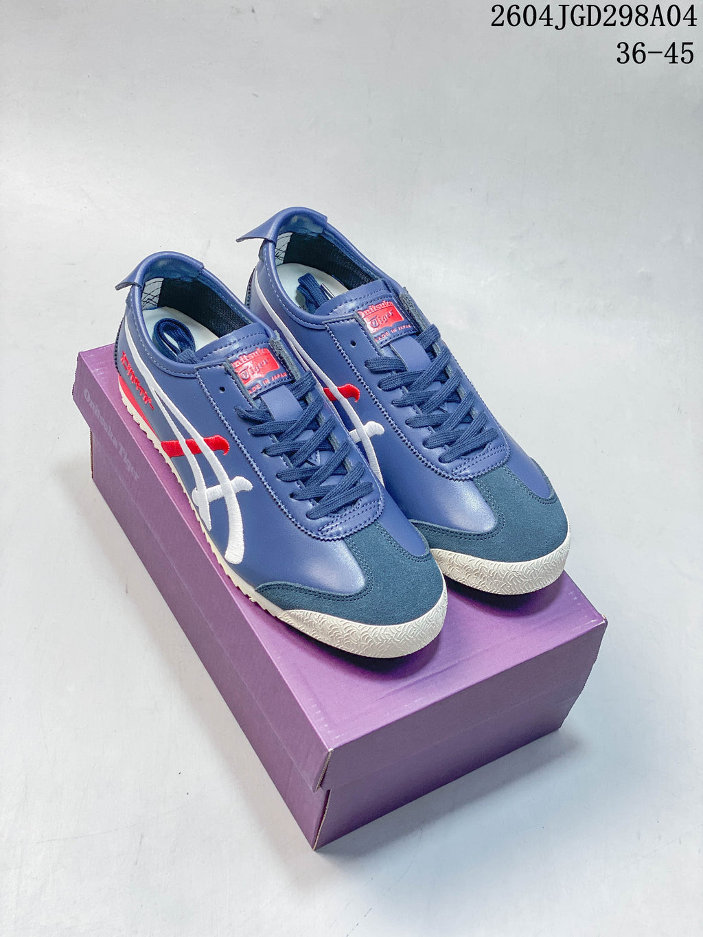 Pair of blue Onitsuka Tiger Mexico 66 Deluxe sneakers on a purple box
