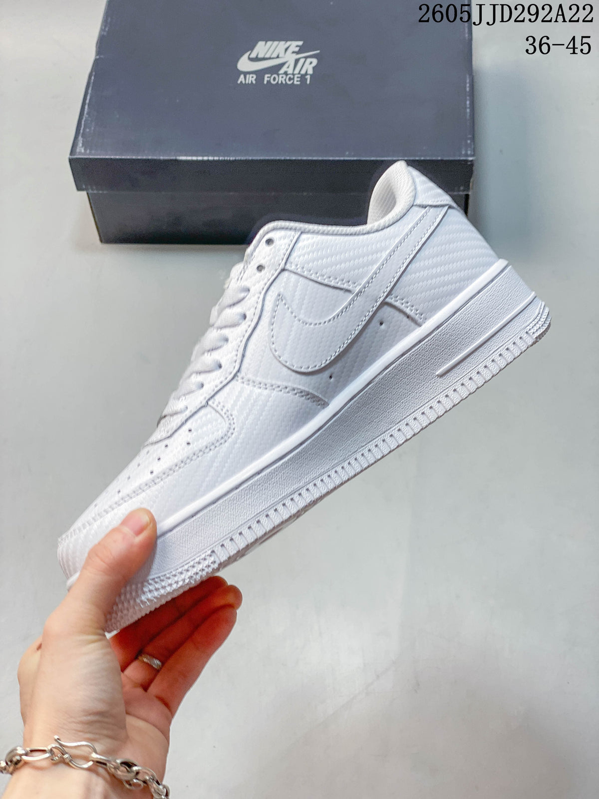Side view of a white low-top sneaker with layered panels