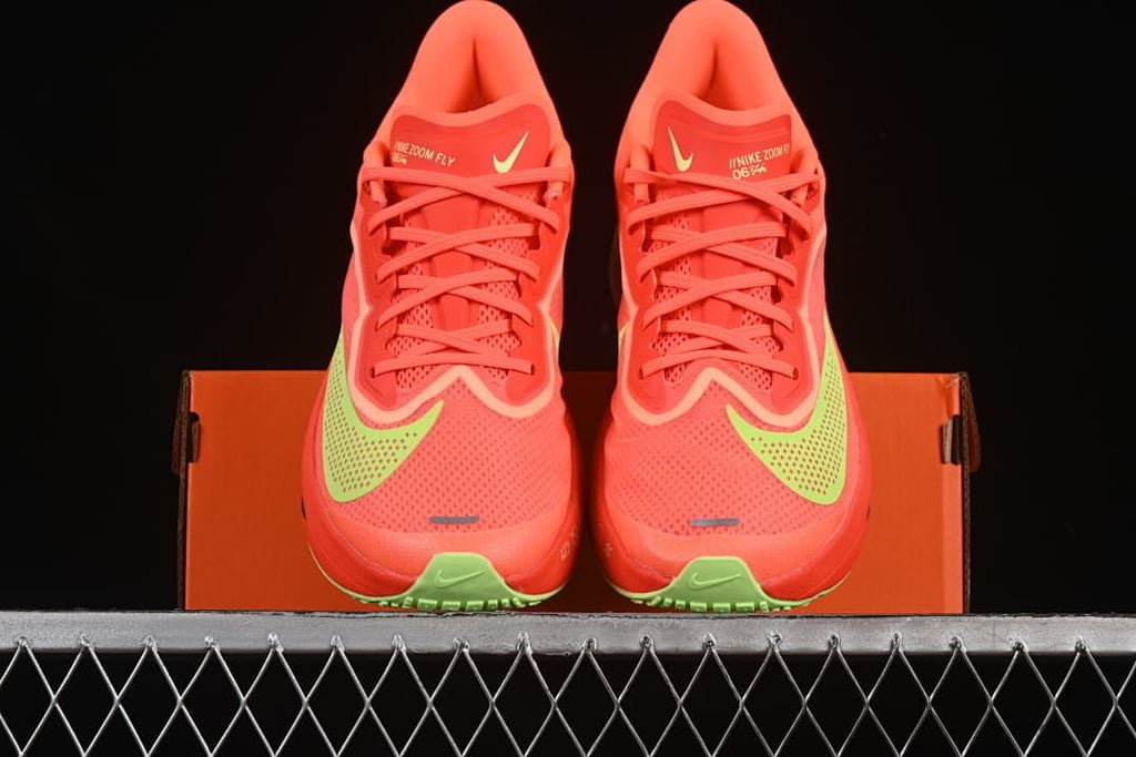 Front view of the pair of coral running shoes displayed on the box
