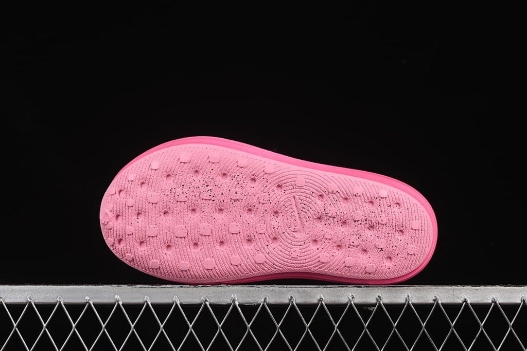Bottom view of the pink clog outsole with textured traction pattern.